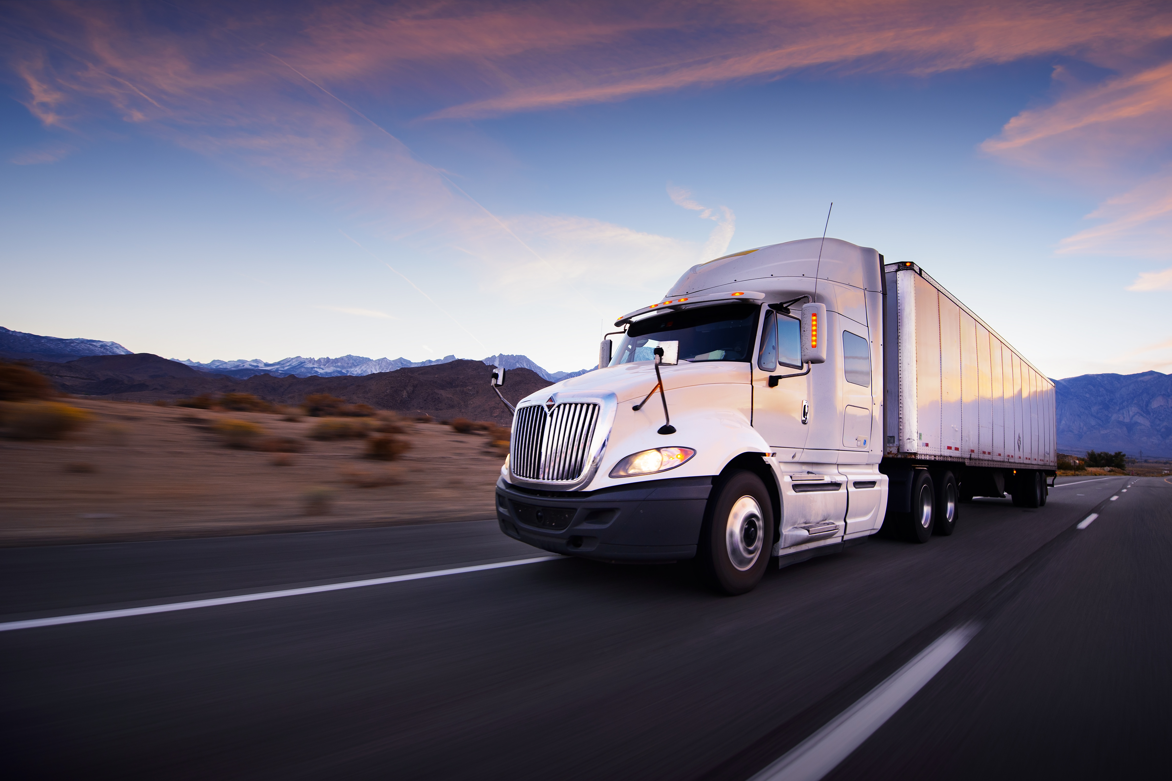 Truck and highway at sunset – transportation background Image of large cargo truck on road that use GPS tracking software